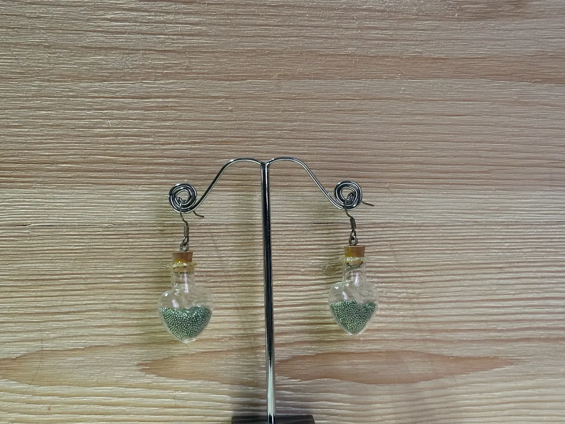 Boucle d'oreilles argentée fiole en coeur avec microbilles vertes en acier inoxydable