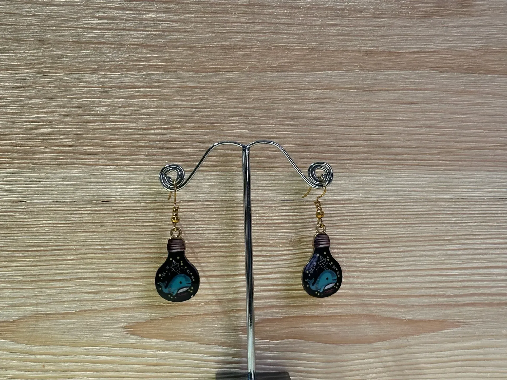 Boucle d'oreilles dorées en forme d'ampoule avec une petite baleine en acier inoxydable