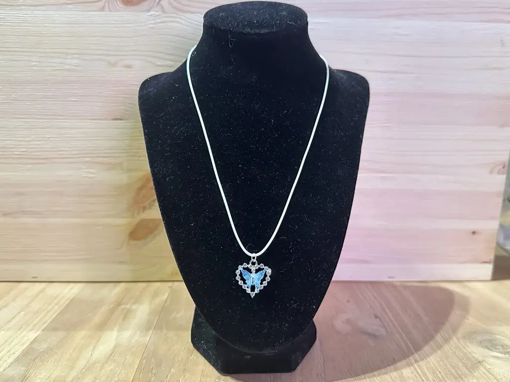 Collier cordon blanc avec papillon bleu dans un cœur 40 à 45cm