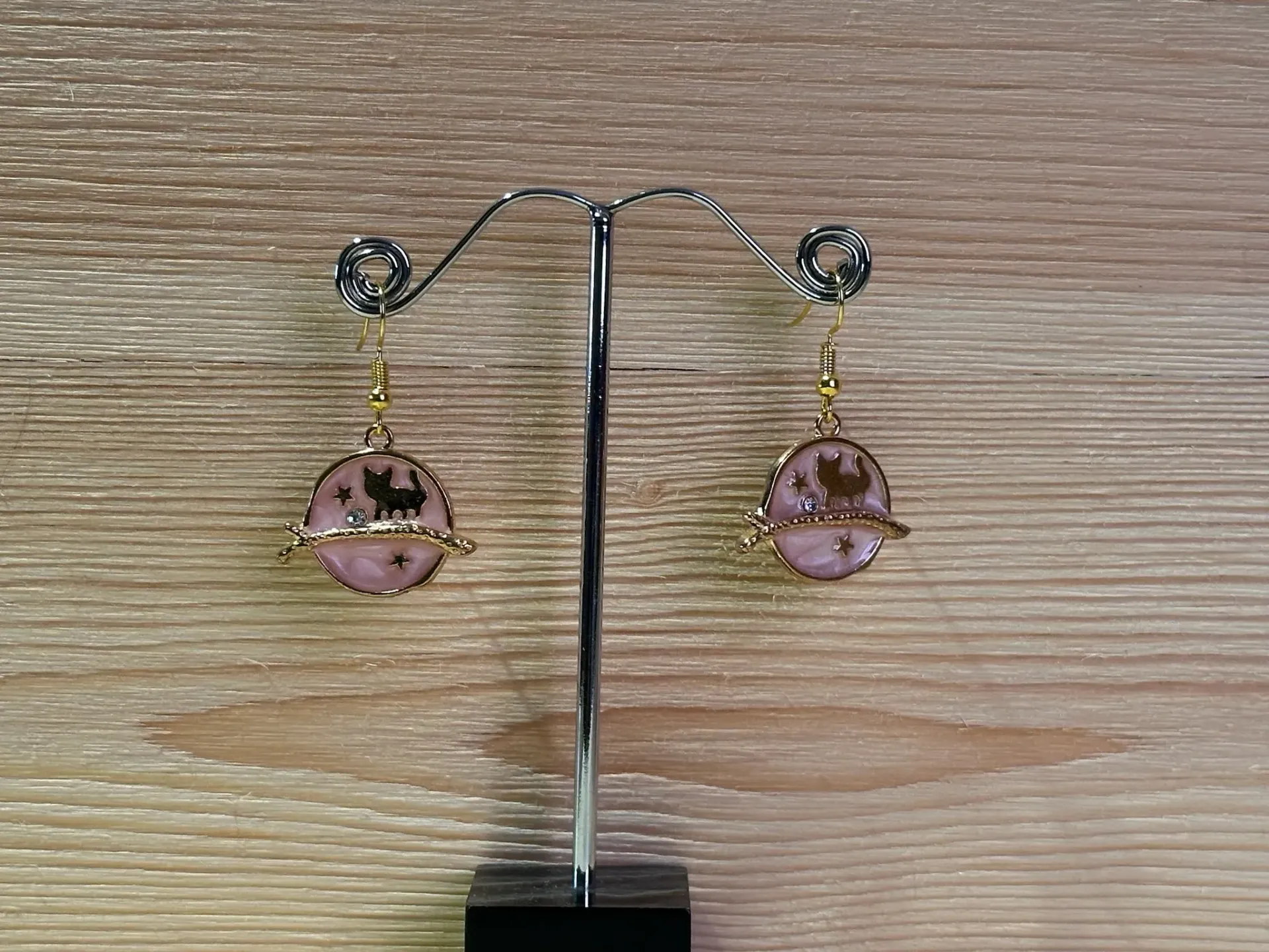 Boucle d'oreille dorée chat sur fond rose en acier inoxydable