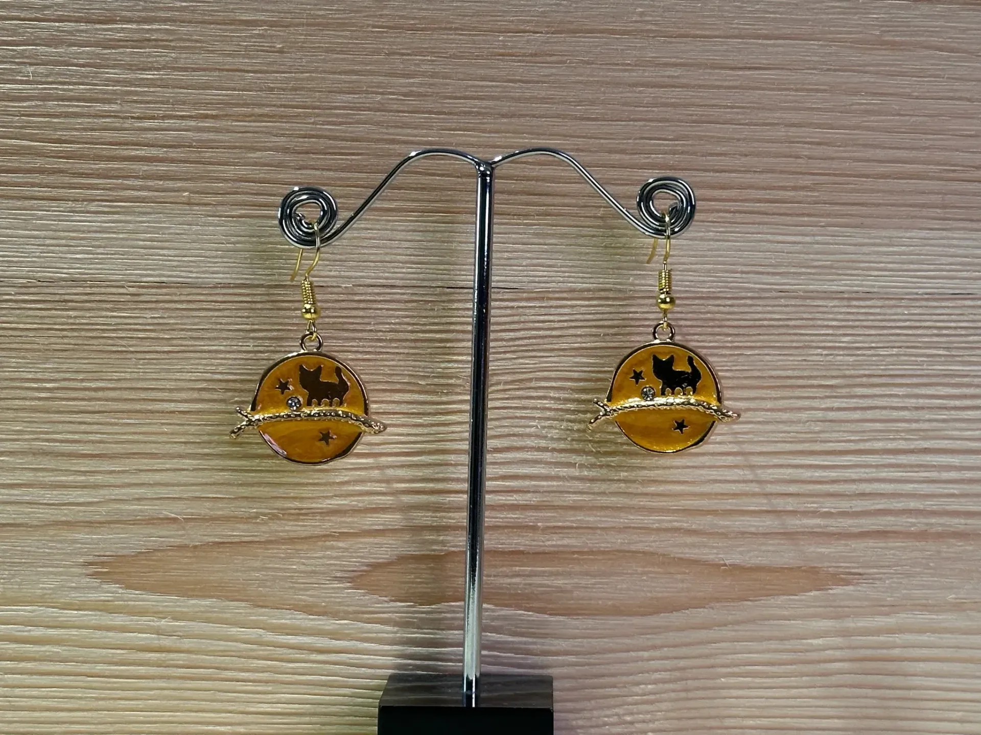 Boucle d'oreille dorée chat sur fond jaune en acier inoxydable